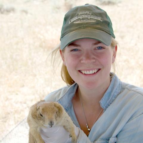 A young woman holds a prairie dog