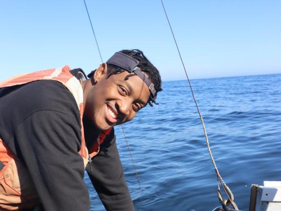 A smiling college student on a boat.