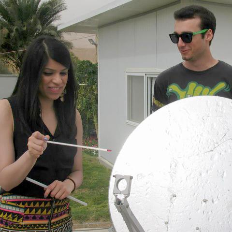 Two college students work with a solar panel