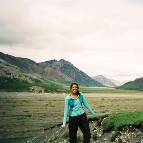 A woman hiking with mountains in the background