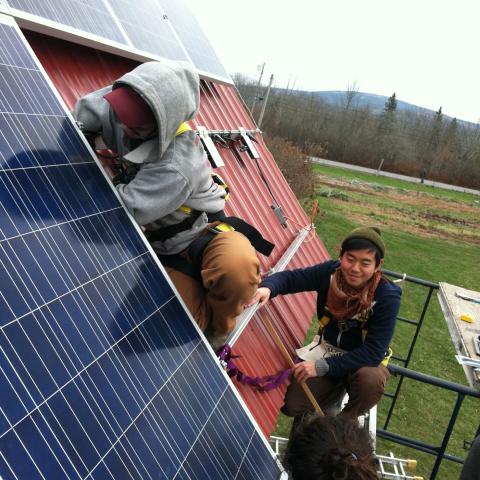 Students on a roof installing solar panels