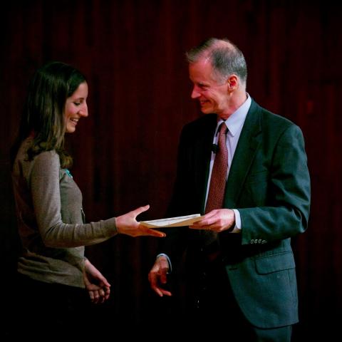 A man hands a student an award at the MIT Climate CoLab