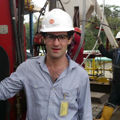 A man in a hard hat at an oil rig