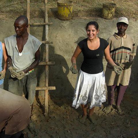 Men and women stand in the mud