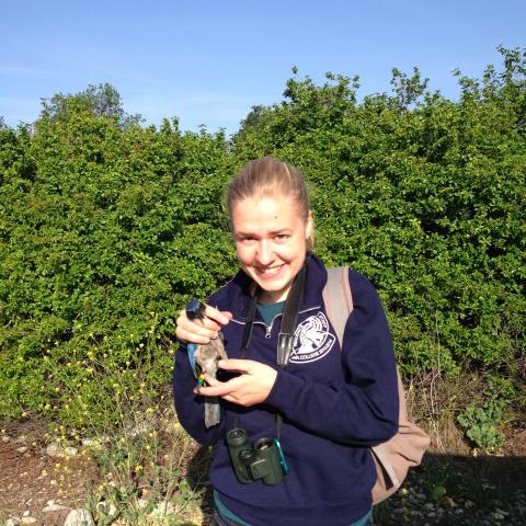 A student holding a bird.