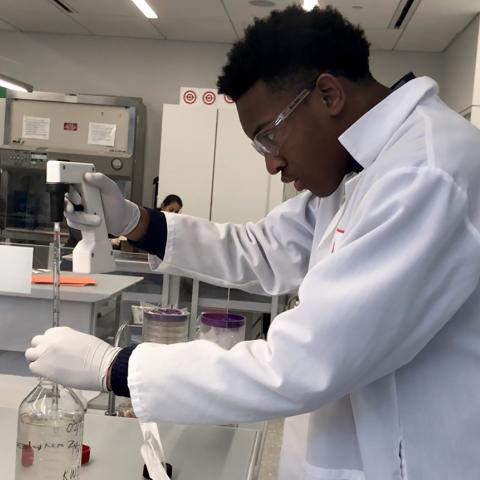 A student works with scientific equipment in a lab.