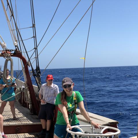 A young woman conducting research on a tall ship.