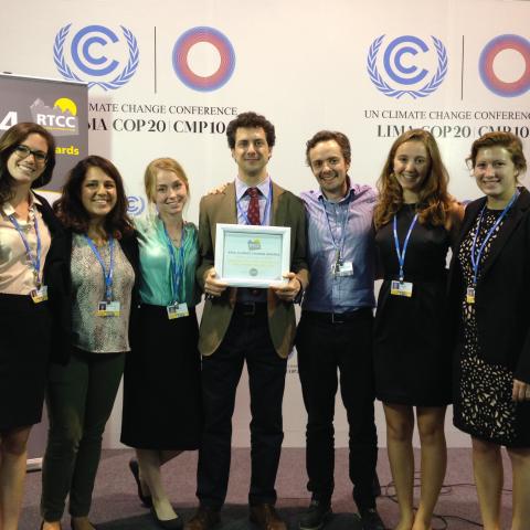 A group of people display an award