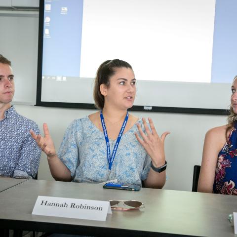 Three students talking at a conference table
