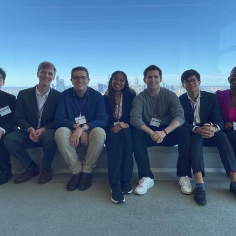 A group of people sit in front of a glass window