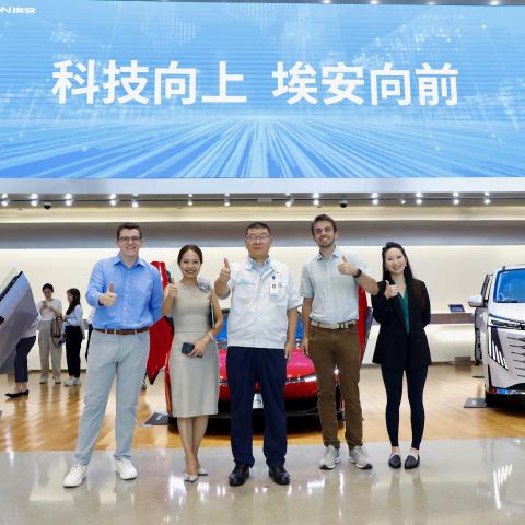 A group of people standing in front of electric vehicles