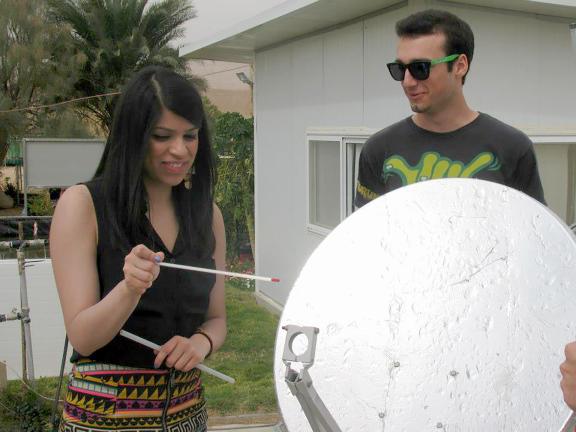 Two college students work with a solar panel