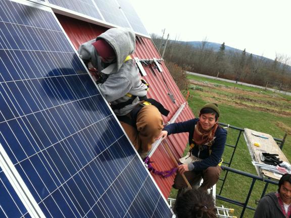 Students on a roof installing solar panels