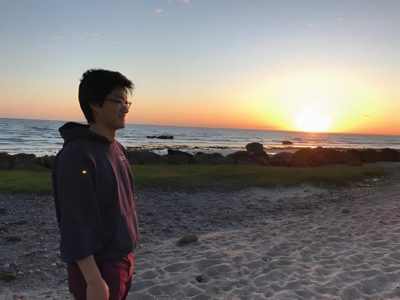 A person at the beach with the sun setting