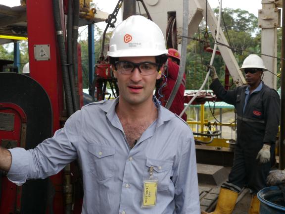 A man in a hard hat at an oil rig