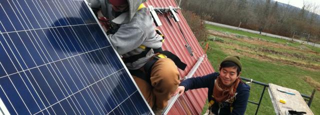 Students on a roof installing solar panels